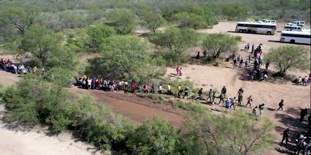 Drone footage shows a large group of migrants crossing the USMexico