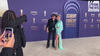 Jason Aldean and wife Brittany pose together on the 2024 ACM red carpet