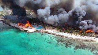 Flames blaze from a fire at the Dominican Republic resort town Bayahibe