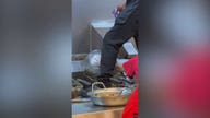 Panda Express worker steps around food while cleaning fry station
