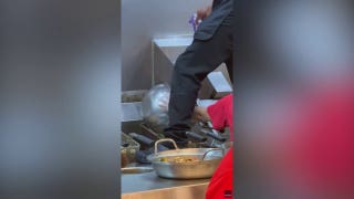 Panda Express worker steps around food while cleaning fry station