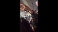 Passengers scramble for belongings during plane evacuation due to smoke