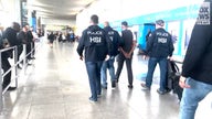 Homeland Security Investigations agents escort flight attendant out of JFK airport in NYC