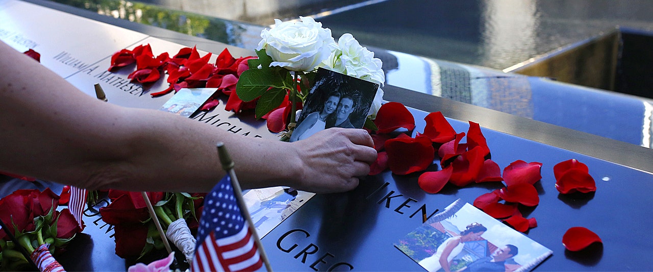 PHOTO IN HAND ROSES ON MEMORIAL