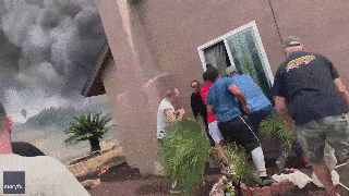 California plane crash: Dramatic video shows bystanders rescuing woman from burning home