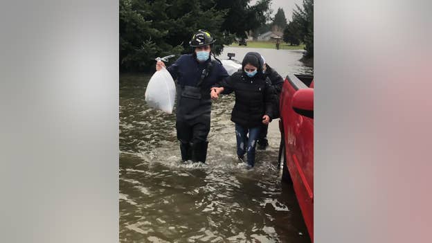 Firefighters help evacuate residents stranded in floodwaters