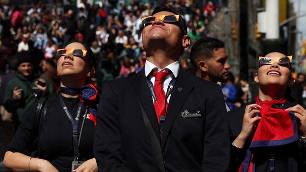 Flight attendants stare at solar eclipse in NYC's Times Square