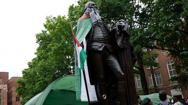 GWU anti-Israel protester drape statue of George Washington in keffiyeh, Palestinian flag