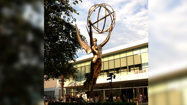 What is the Emmy statuette holding?