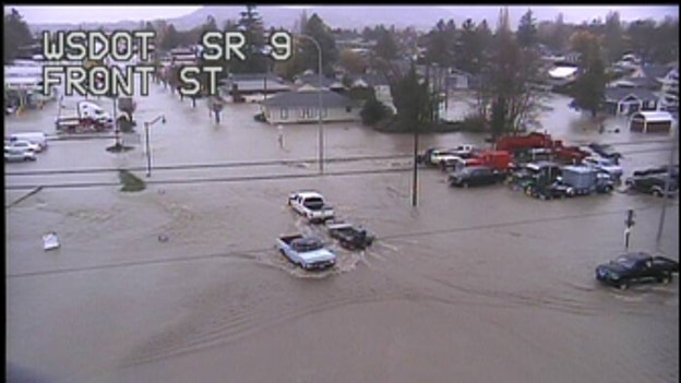 Cars drive through flood waters in Sumas, Wash.