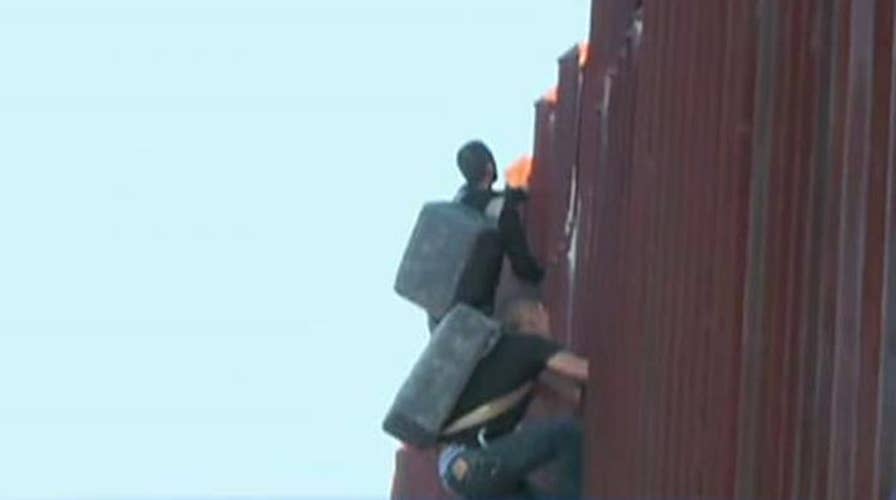 Two suspected drug smugglers caught climbing fence into US
