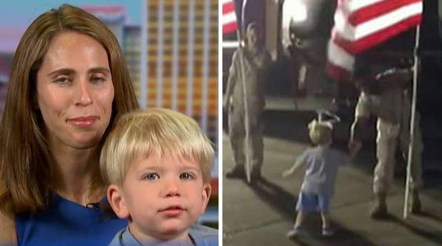 Little boy runs across tarmac to shake hands with servicemen