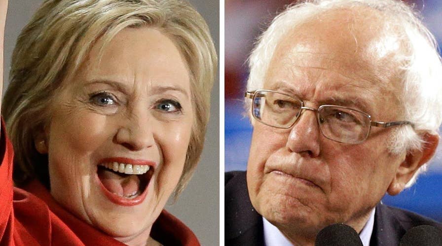 Clinton reaches delegate threshold; Sanders vows to fight on