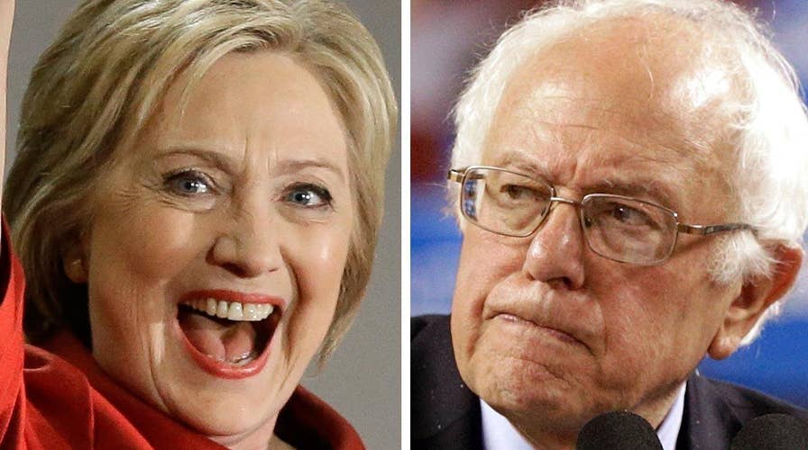 Clinton reaches delegate threshold; Sanders vows to fight on