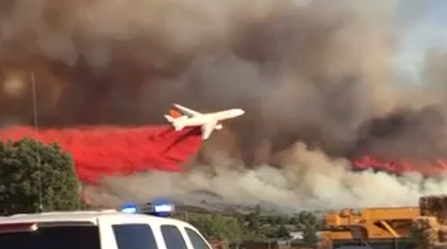 Giant tanker swoops dangerously low to douse wildfire