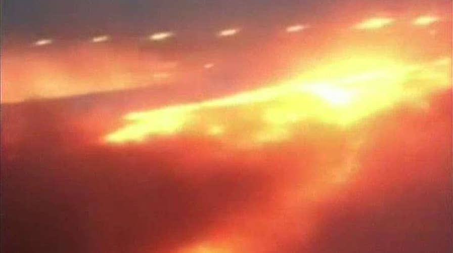 Passengers watch in horror as plane wing bursts into flame