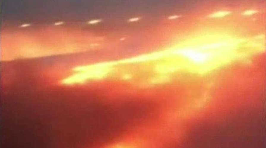 Passengers watch in horror as plane wing bursts into flame