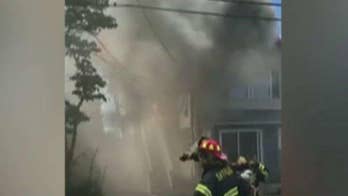 Police officer catches baby tossed from window of burning home