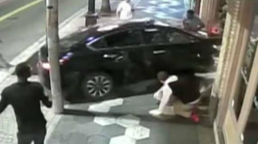 Car crashes through street brawl, into bar