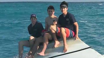 Photo shows 3 teens huddled on capsized boat miles off Florida