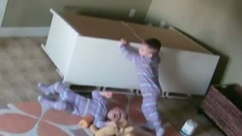 Caught on video: 2-year-old boy pushes dresser off twin brother stuck underneath