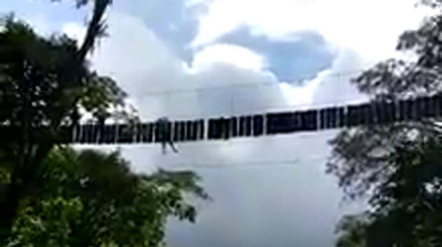 Person hangs from rope bridge after deadly collapse