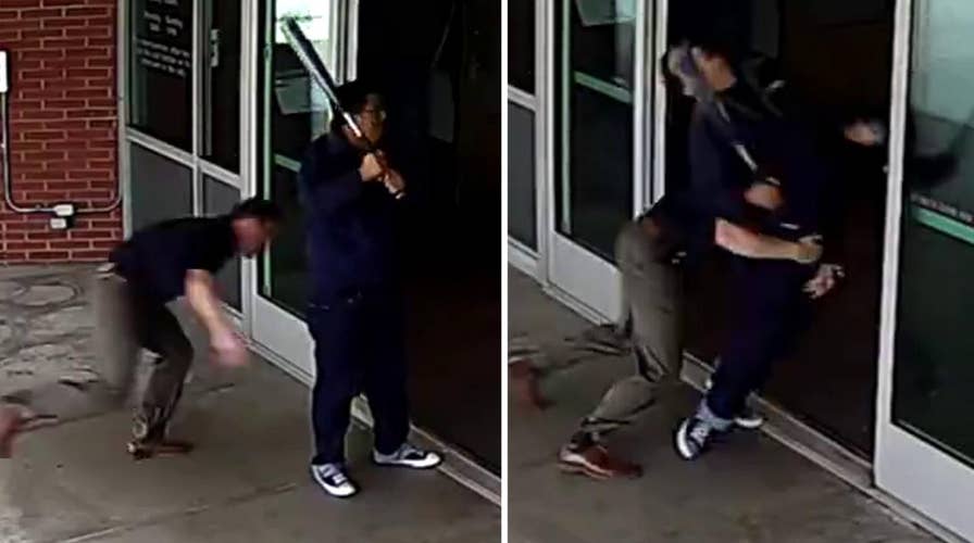 Cop blindsides bat-wielding man outside police department