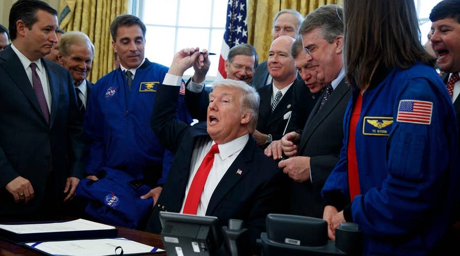 Trump signs NASA bill, pushes Mars missions