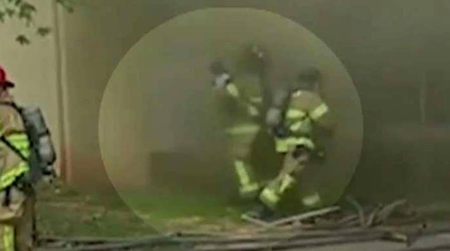 Hero firefighter catches baby dropped from burning building