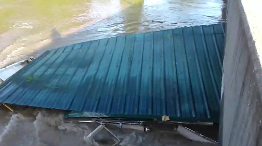 House swept up by powerful flood water, crashes into bridge