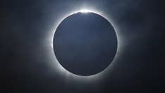 What causes a total solar eclipse?