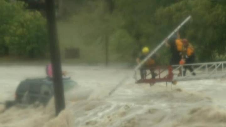 Rescue crew works to pull SUV driver from deadly floodwaters