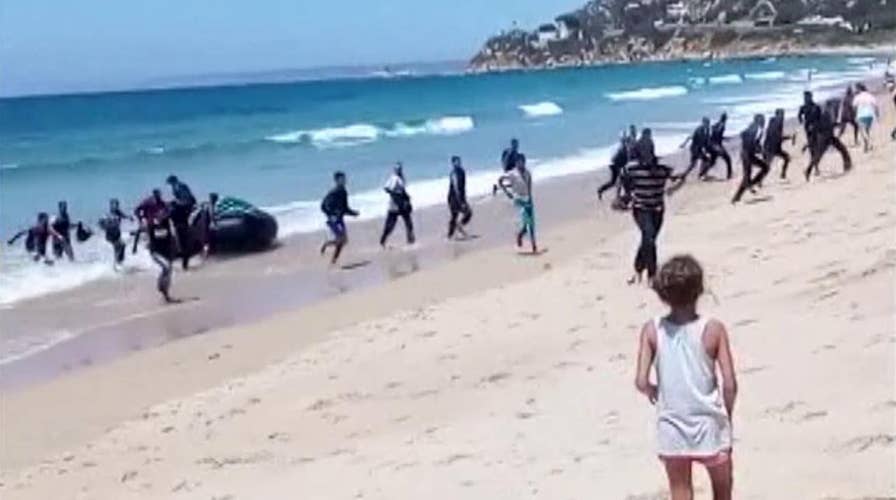 Sunbathers shocked as migrants storm Spanish beach