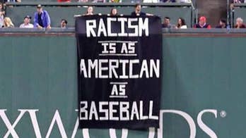 Boston Red Sox fans hang 'racism is as American as baseball' sign above Green Monster during game