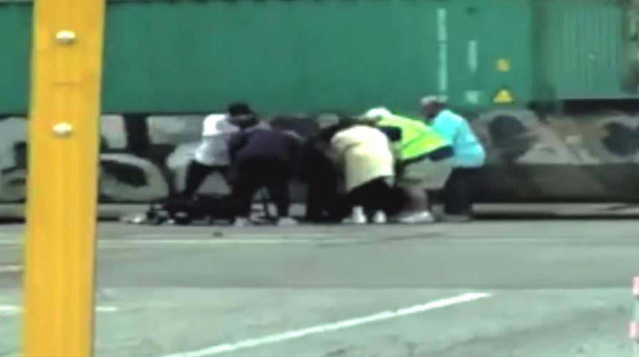 Woman saves man in wheelchair stuck on train tracks