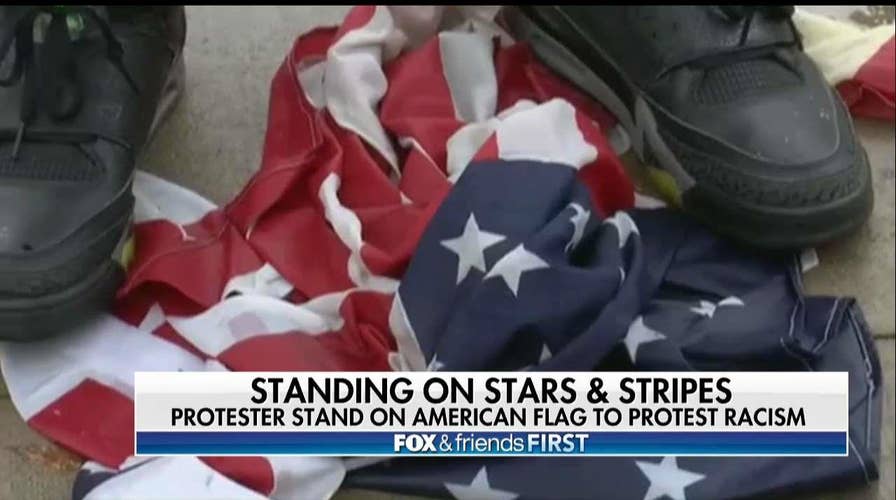 Man Stands on American Flag Outside Pennsylvania Courthouse to Protest Racism