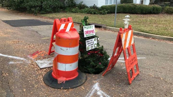 Christmas tree in pothole draws attention to crumbling roads