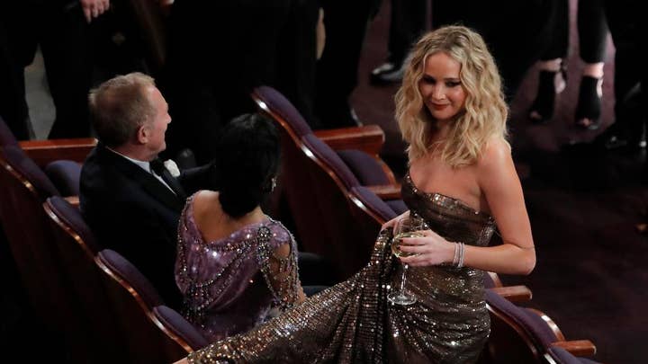 Academy Awards: Jennifer Lawrence juggles wine, climbs over chair