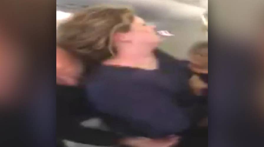 Woman on airplane tries to open cabin door mid-flight