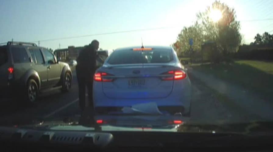 Raw video: Suspect flees scene with officer in his car