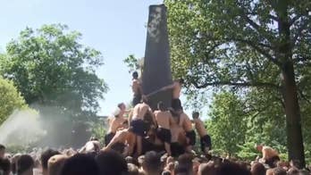 Naval Academy freshmen climb greased Herndon Monument in annual tradition
