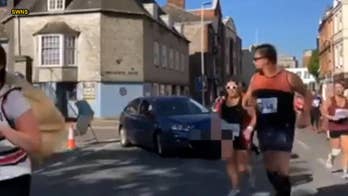 Angry woman caught driving her car into path of half marathon
