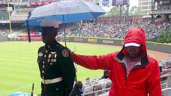 Fan shields JROTC member from rain in powerful photo