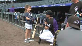 Nevada girl, 8, with robotic hand throws first pitch at Colorado Rockies game