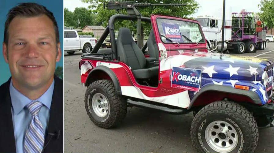 Left slams Kris Kobach for fake gun on jeep
