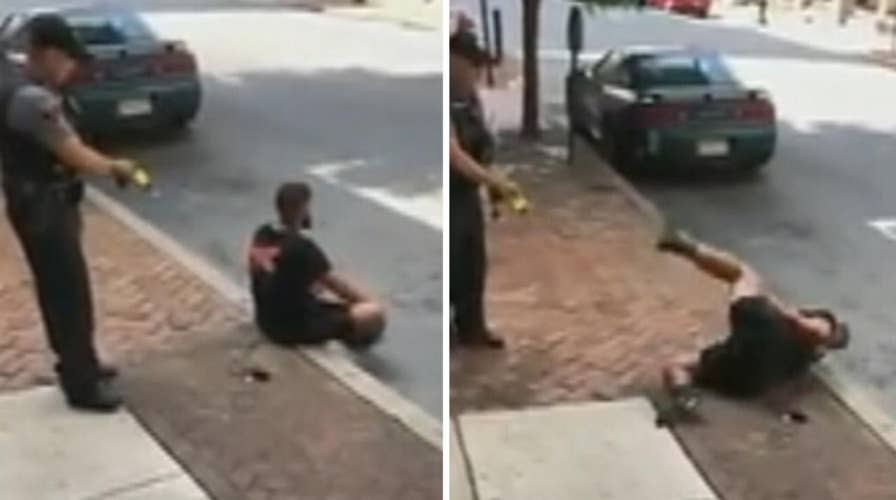 Cop uses stun gun on man sitting on curb