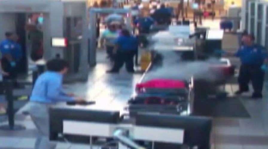 TSA officer removes smoking bag from security checkpoint