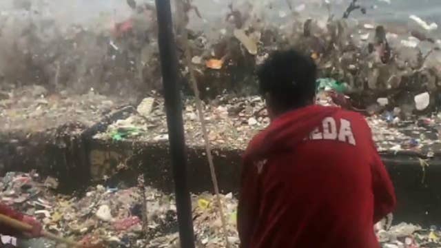 Volunteers struggle to clean garbage washing ashore