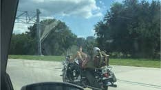 Florida motorcyclist seen leaning back, using feet to steer vehicle on interstate