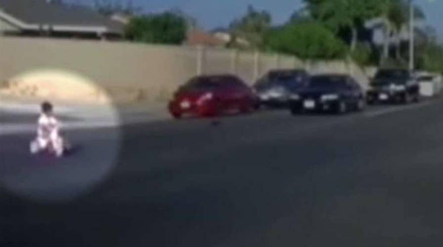 Cars narrowly miss boy on tricycle who rolled into traffic